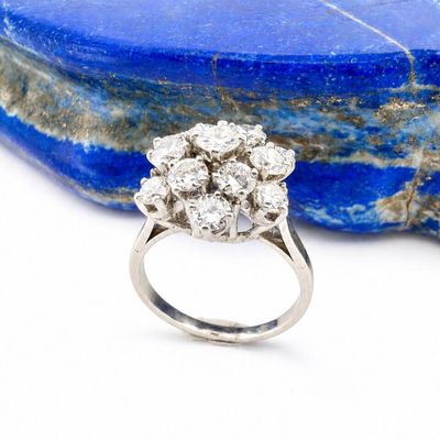une photo en gros plan d'une bague en diamant posée sur un rocher