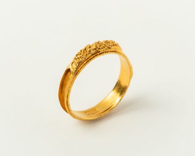 gros plan d'une bague en or sur une surface blanche