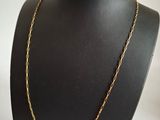 a black mannequin with a gold chain on it