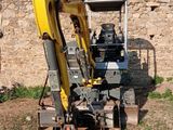 une pelleteuse jaune qui est à l'arrêt dans la terre