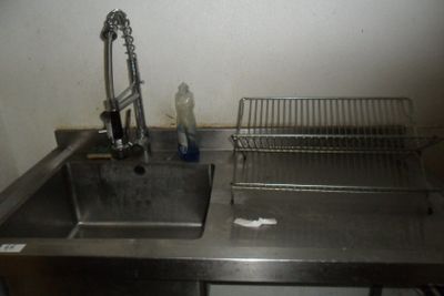 un évier en acier inoxydable avec une grille métallique et un robinet
