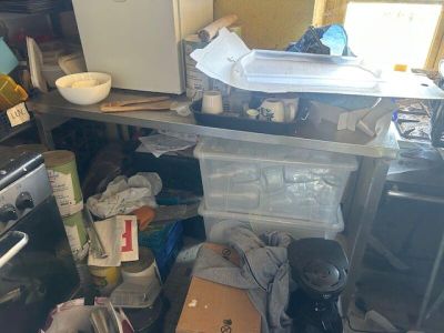 a kitchen with a lot of clutter on the floor