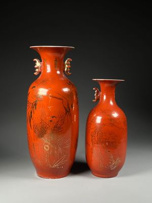 une paire de vases orange ornés de motifs sur fond noir