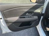 l'intérieur d'une voiture dont la portière est ouverte et où se trouve un chien sur le siège passager
