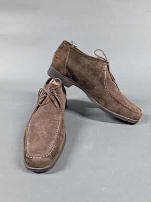 a pair of brown sued shoes sitting on top of a gray surface