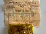 un lingot d'or posé à côté d'un ticket de caisse sur une table