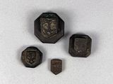 three pieces of metal with a face on them on a white surface