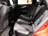 the back seats of a red car with a black seat belt