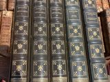 Plusieurs vieux livres sont empilés sur une table dans une bibliothèque