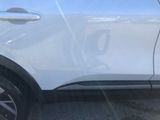 a close up of a white car parked in a parking lot