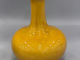 a yellow vase that is sitting on a table