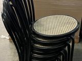 quatre chaises noires alignées les unes à côté des autres sur le trottoir