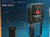 Coffret du système de nivellement laser Bosch Professional posé sur une table en bois