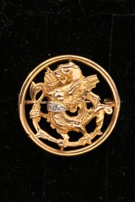 une image représentant une broche plaquée or ornée d'un dragon