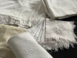 une pile de linge de maison blanc orné de monogrammes brodés