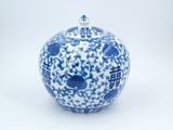 a blue and white vase with a lid on a white surface