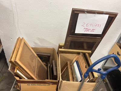 une pile de cartons et un chariot sur lequel est accrochée une pancarte