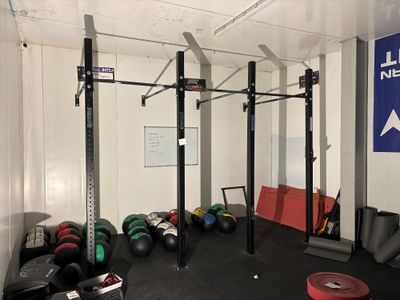 une photo d'une salle de sport avec un support à haltères et des poids