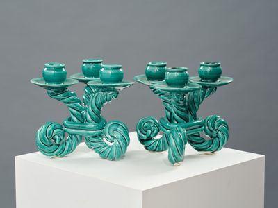 trois bougies vertes posées sur un socle blanc