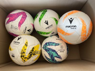 six ballons de football dans une boîte, chacun avec un motif différent
