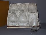 six empty wine glasses in a box on a table