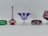 quatre vases en verre de couleurs différentes posés sur une surface blanche