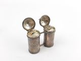 pair of antique silver plated salt and pepper shakers on a white background
