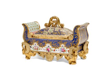 a blue and gold covered box with flowers on it