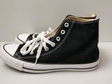 baskets montantes Converse noires avec des lacets blancs sur fond blanc