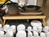 many white and black plates and cups on a shelf