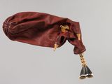 a bag that has a bell hanging from it ' s side