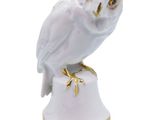 an owl figurine sitting on top of a white pedestal