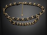 un collier noir et doré, composé d'une chaîne sur laquelle est inscrit le mot « Chanel »
