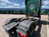 a green semi truck parked in a parking lot