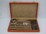 an orange case holds a set of silverware including a spoon, spoon and spoon rest