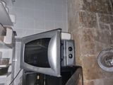un micro-ondes posé sur un réfrigérateur dans une cuisine