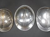 three silver hard hats sitting on top of a black table