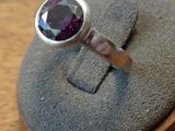 a silver ring with a purple stone on top of it