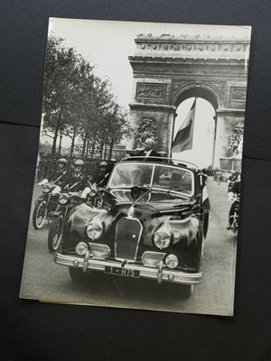a black and white photo of a car with a flag on top of it