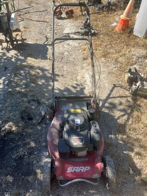 a red lawn mower that is sitting on the ground