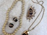 collier, bracelet et bague dorés et noirs, avec un pendentif en forme de soleil