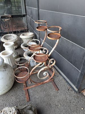 de nombreux pots et vases posés par terre à l'extérieur d'un bâtiment