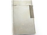 un briquet argenté posé sur une surface blanche