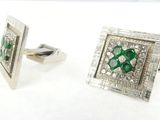 une paire de boutons de manchette en émeraude et diamant sur fond blanc