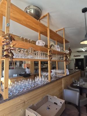 a bar with wine glasses on the shelves above it