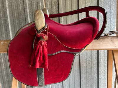a red saddle with a tassel hanging from it