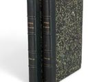 two books sitting on top of each other on a white surface