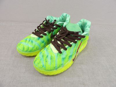 green and brown sneakers with brown laces on a gray surface