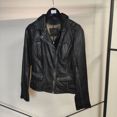 une veste en cuir noir suspendue à un portant dans une pièce