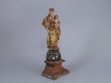 statue of a woman holding a child on top of a globe